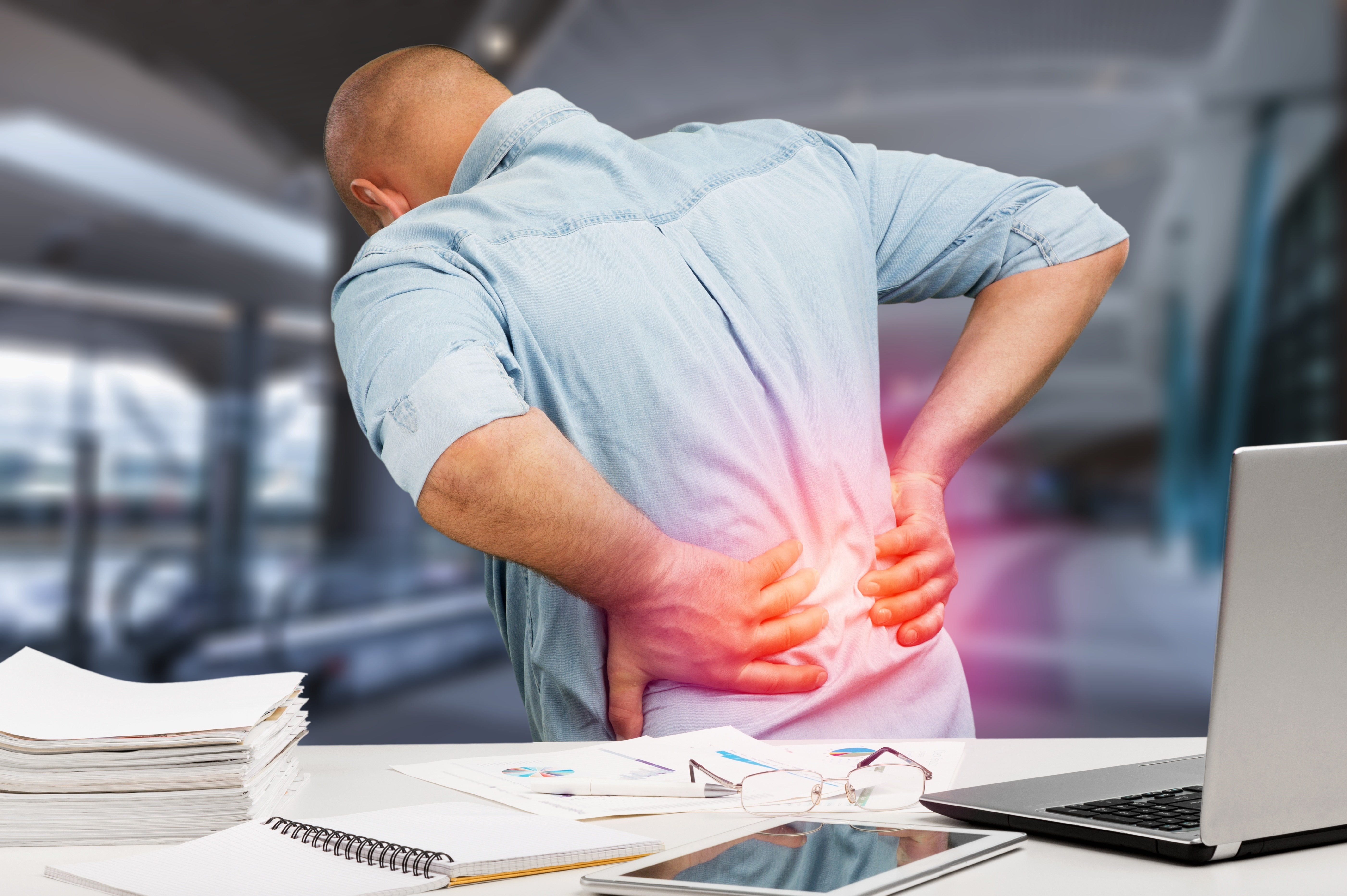 Person holding lower back in pain — back pain treatment Pittsburgh PA